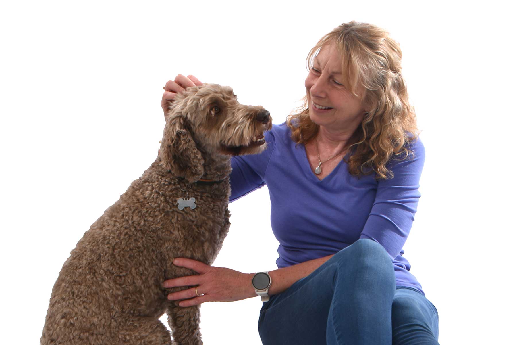 helen & barney the brown cockerpoo sat together helen looking at petting barney on white background