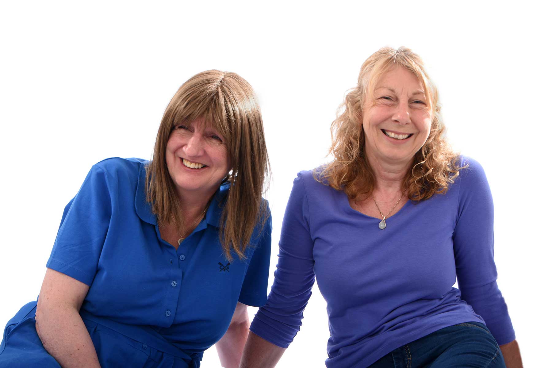 Nina & Helen sitting laughing together white background